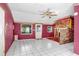 Bright living room featuring white tile floors, floral wallpaper, and views of the front yard at 10130 Burton St, New Port Richey, FL 34654