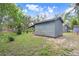 Exterior view of a shed with a gray exterior and surrounding greenery at 10130 Burton St, New Port Richey, FL 34654