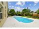Backyard with a sparkling pool, lush landscaping, and a well-maintained lawn offers the perfect outdoor oasis at 10223 Charleston Corner Rd, Tampa, FL 33635
