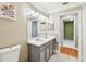 Bathroom with double sinks, large mirror, and doorway access to other rooms at 10223 Charleston Corner Rd, Tampa, FL 33635