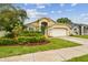Attractive home with beautiful landscaping, a blue entry door and a two-car garage at 10223 Charleston Corner Rd, Tampa, FL 33635