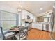 Bright kitchen features white cabinets, stainless steel appliances, eat in breakfast nook, and wood flooring at 10223 Charleston Corner Rd, Tampa, FL 33635