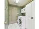 Laundry room features tile floors, white cabinets, and modern washer and dryer units at 10223 Charleston Corner Rd, Tampa, FL 33635