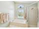 Relaxing main bathroom features tub with shower and a window overlooking the backyard pool at 10223 Charleston Corner Rd, Tampa, FL 33635