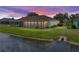 Scenic backyard with lush green lawn, tranquil pond, sunroom, and extended patio at 10324 Chatuge Dr, San Antonio, FL 33576