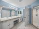 Large bathroom with double sinks, a walk-in shower, and tiled floors at 10324 Chatuge Dr, San Antonio, FL 33576