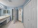 Spacious bathroom with double sinks, a glass shower, and a closet at 10324 Chatuge Dr, San Antonio, FL 33576