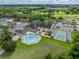 Aerial view of community clubhouse with swimming pool, shuffleboard, and parking at 10324 Chatuge Dr, San Antonio, FL 33576