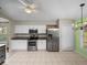 Well-lit kitchen featuring stainless steel appliances and white tile floors at 10324 Chatuge Dr, San Antonio, FL 33576