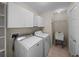Laundry room featuring a washer, dryer, laundry tub, overhead cabinets and shelving at 10324 Chatuge Dr, San Antonio, FL 33576