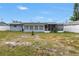 View of backyard with a fence, small tree, screened patios, and the back of the home at 11315 86Th Ave, Seminole, FL 33772