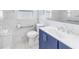 Modern bathroom with a blue vanity, white marble tiling, and updated fixtures and hardware at 11315 86Th Ave, Seminole, FL 33772