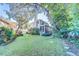 Large grassy backyard with mature trees and screened porch, perfect for outdoor enjoyment at 11386 Churchhill Trl, Seminole, FL 33772