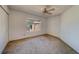 Bedroom with neutral carpet, ceiling fan, and a window letting in natural light at 11386 Churchhill Trl, Seminole, FL 33772