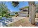 A two-story home boasts a garage and a driveway bordered by landscaping, shaded by mature trees at 11386 Churchhill Trl, Seminole, FL 33772