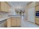 Bright kitchen featuring light wood cabinets, stainless steel appliances, and an open layout leading to the living room at 11386 Churchhill Trl, Seminole, FL 33772