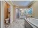 Main bathroom features a soaking tub, a separate shower, and double sink vanity with a large mirror at 11386 Churchhill Trl, Seminole, FL 33772
