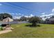 Spacious backyard featuring a lush lawn, mature tree, and patio furniture, perfect for outdoor entertaining at 1142 56Th N Ave, St Petersburg, FL 33703