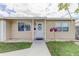Charming house with a white door, decorative wreath, and lovely flowers, surrounded by a green lawn at 1142 56Th N Ave, St Petersburg, FL 33703