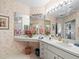Bathroom showcasing double vanity, multiple mirrors, and floral wallpaper at 11510 Shipwatch Dr # 1375, Largo, FL 33774