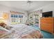 Cozy bedroom featuring a window view, TV, and a comfortable floral-themed bed at 11510 Shipwatch Dr # 1375, Largo, FL 33774
