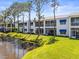 A relaxing exterior view from the water of this condominium with bright blue awnings on a sunny day at 11510 Shipwatch Dr # 1375, Largo, FL 33774