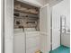 Laundry room featuring washer, dryer, shelving, and open bi-fold doors at 11510 Shipwatch Dr # 1375, Largo, FL 33774