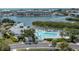 Aerial view of a pool and boat docks on the water with beautiful landscaping and blue umbrellas at 11510 Shipwatch Dr # 1375, Largo, FL 33774