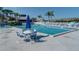 Community pool area features a table with umbrella and chairs to enjoy the sunny weather at 11510 Shipwatch Dr # 1375, Largo, FL 33774