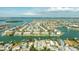 An aerial view highlights canal-front homes in a community surrounded by water and lush landscaping at 12412 Lagoon Ln, Treasure Island, FL 33706