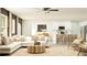 Spacious living room open to kitchen with white sofa and wood accents at 12605 Aura Moonlight Ter, Parrish, FL 34219