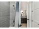 Bathroom features a gray tiled shower, elegant fixtures, and a modern vanity, perfect for a refreshing and stylish experience at 12707 Green Heron Way, Odessa, FL 33556