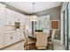 Eat-in kitchen area with a round wooden table, upholstered chairs and bright window with shutters at 12707 Green Heron Way, Odessa, FL 33556