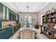 Stylish dining room features a wet bar with green cabinets and modern light fixtures at 12707 Green Heron Way, Odessa, FL 33556