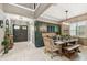Elegant dining room with stylish dark green cabinetry, modern lighting, and entry door at 12707 Green Heron Way, Odessa, FL 33556