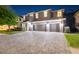 Elegant two-story home featuring a spacious three-car garage and a well-manicured lawn at 12707 Green Heron Way, Odessa, FL 33556