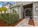 Inviting front entrance with double doors, a stone facade, and lush landscaping at 12707 Green Heron Way, Odessa, FL 33556