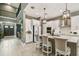 Modern kitchen with white cabinets, center island with chairs and pendant lighting at 12707 Green Heron Way, Odessa, FL 33556
