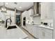Modern kitchen with white cabinets, stainless steel appliances, quartz countertops, and island with breakfast bar at 12707 Green Heron Way, Odessa, FL 33556