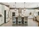 Bright, contemporary kitchen featuring white cabinets, stainless steel appliances, and a large island with bar stools at 12707 Green Heron Way, Odessa, FL 33556
