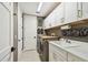 Well-organized laundry area with white cabinets, countertops and modern machines at 12707 Green Heron Way, Odessa, FL 33556