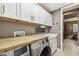 Functional laundry room with modern washer/dryer and bright white cabinetry at 12707 Green Heron Way, Odessa, FL 33556