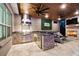 Built-in outdoor kitchen with stainless steel grill, prep area, and nearby outdoor fireplace at 12707 Green Heron Way, Odessa, FL 33556