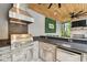 Well-equipped outdoor kitchen featuring stainless steel appliances, stone accents, and ample counter space for cooking at 12707 Green Heron Way, Odessa, FL 33556