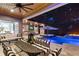 Covered patio with full kitchen, dining, seating, and fireplace overlooking a blue, in-ground pool at 12707 Green Heron Way, Odessa, FL 33556