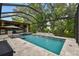 Inviting screened pool with built-in spa, outdoor kitchen, and lush greenery for a relaxing backyard oasis at 12707 Green Heron Way, Odessa, FL 33556