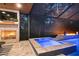In-ground pool with hot tub and fire pit with nearby stone fireplace and mounted TV at 12707 Green Heron Way, Odessa, FL 33556