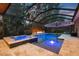 In-ground pool with a hot tub and fire pit, covered with a screened-in enclosure at 12707 Green Heron Way, Odessa, FL 33556