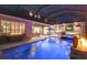 Luxurious covered pool area featuring a spa, outdoor kitchen, and comfortable lounge seating at 12707 Green Heron Way, Odessa, FL 33556
