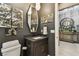 Stylish powder room with modern fixtures, dark accent wall and wood-look floors at 12707 Green Heron Way, Odessa, FL 33556